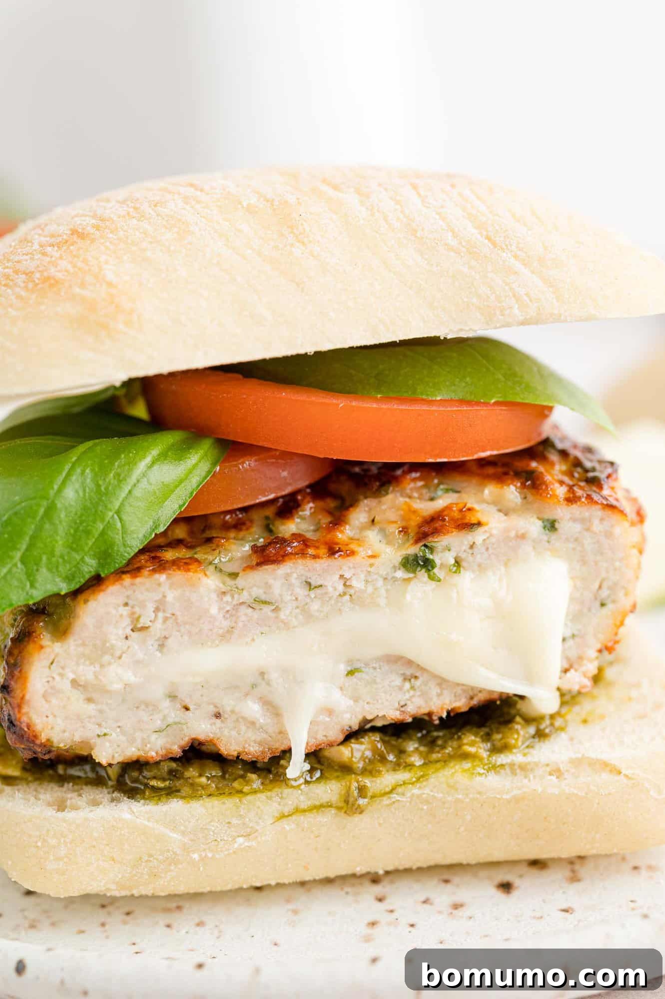 Caprese turkey burger cut to show creamy mozzarella filling, highlighting its delicious core.