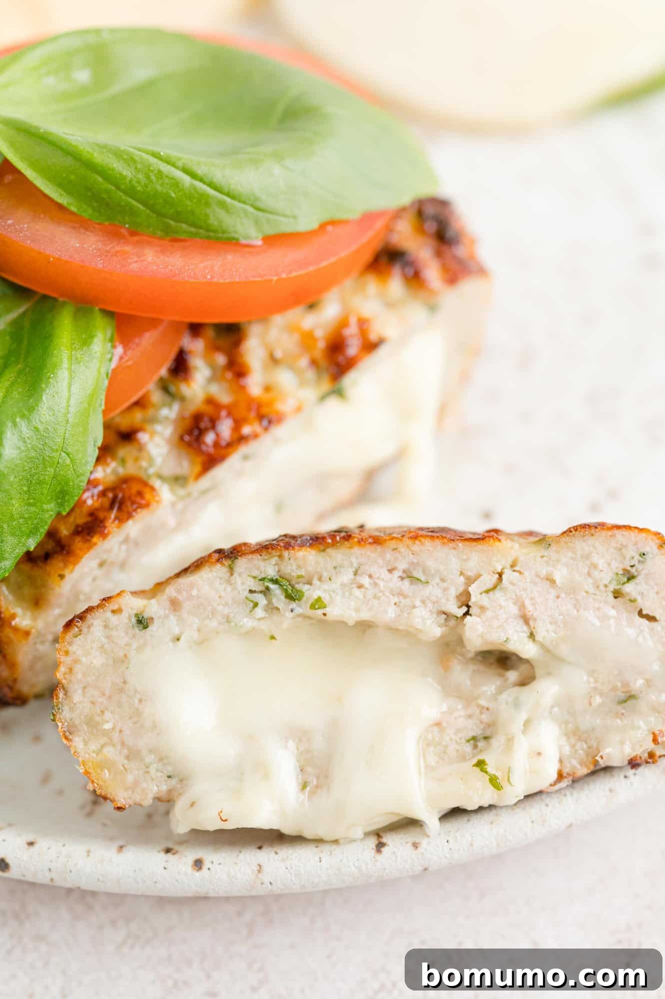 Turkey burger expertly cut open to reveal the perfectly melted mozzarella filling, inviting a closer look.
