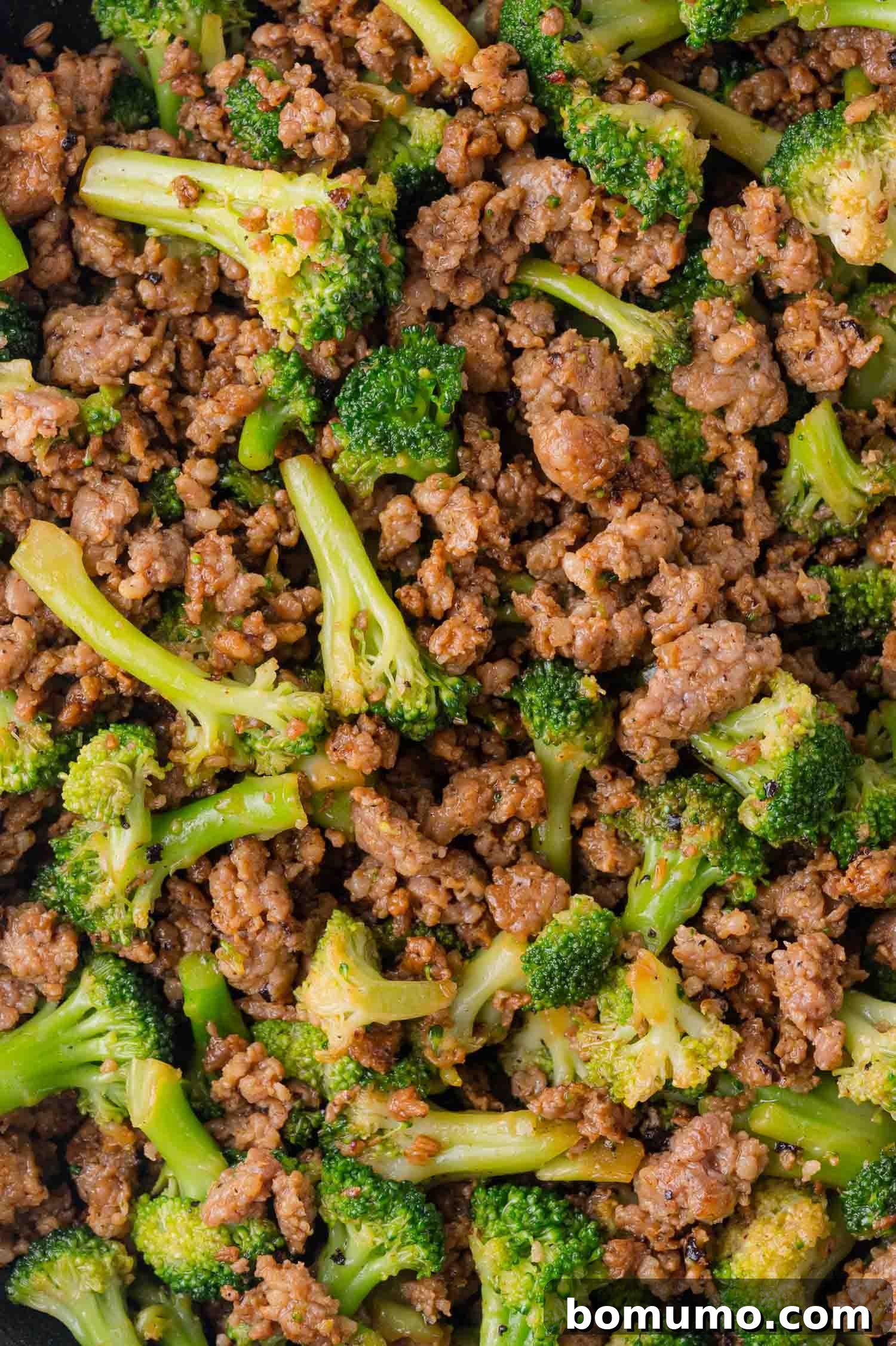 Protein-Packed Egg White Bites 6 Cooked ground sausage mixed with vibrant broccoli florets, seasoned and ready in a skillet, showing the combined mixture.