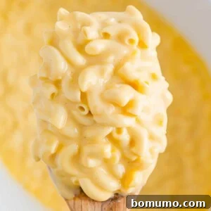 Large scoop of creamy crockpot mac and cheese, ready to be served.