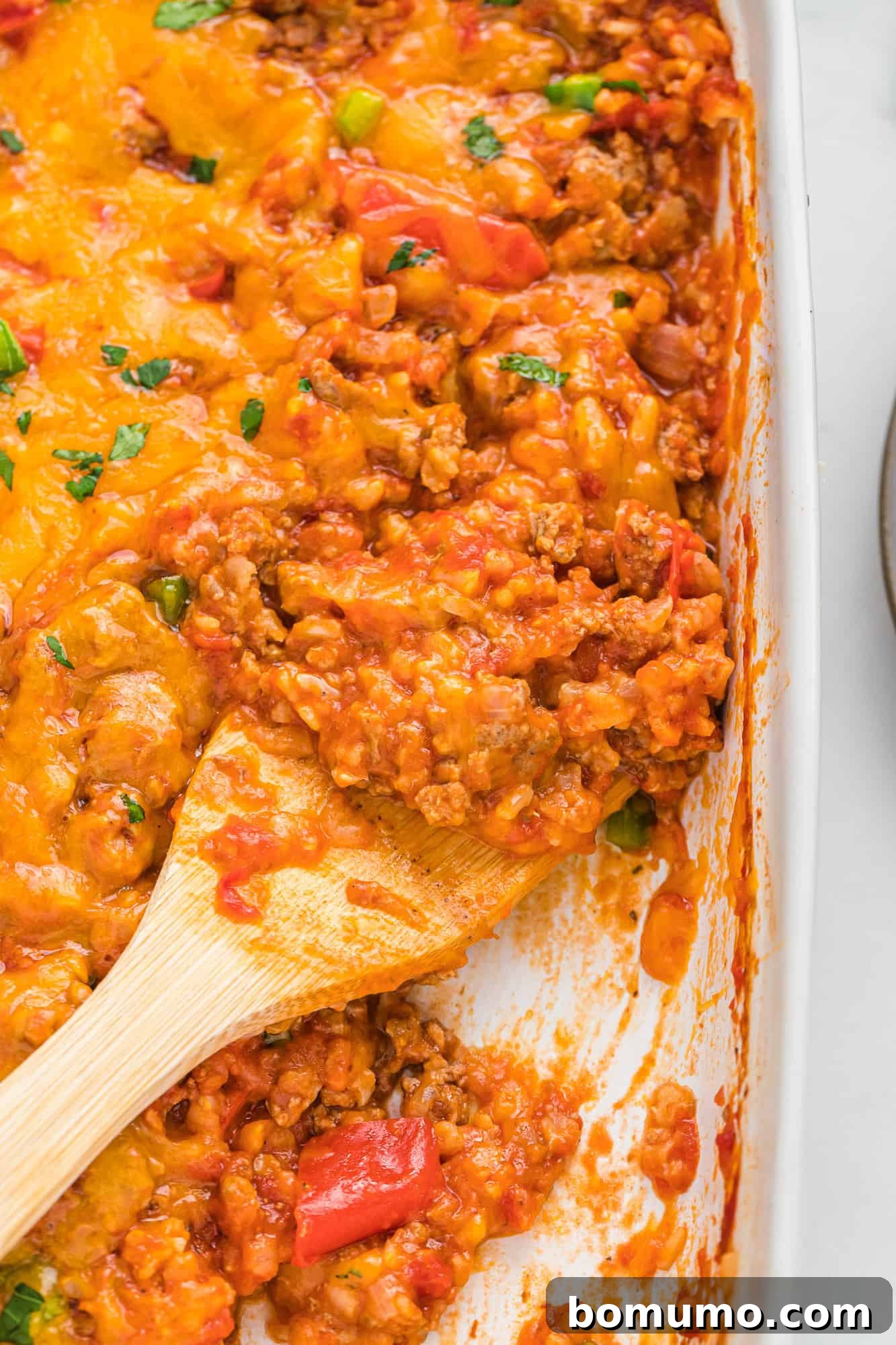 A hearty casserole dish filled with a vibrant mix of tomatoes, tender bell peppers, fluffy rice, and savory ground turkey, ready to be served.