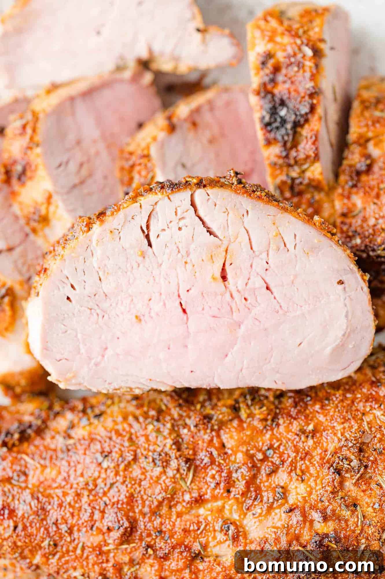 Perfectly cooked slices of air fryer pork tenderloin, expertly stacked.