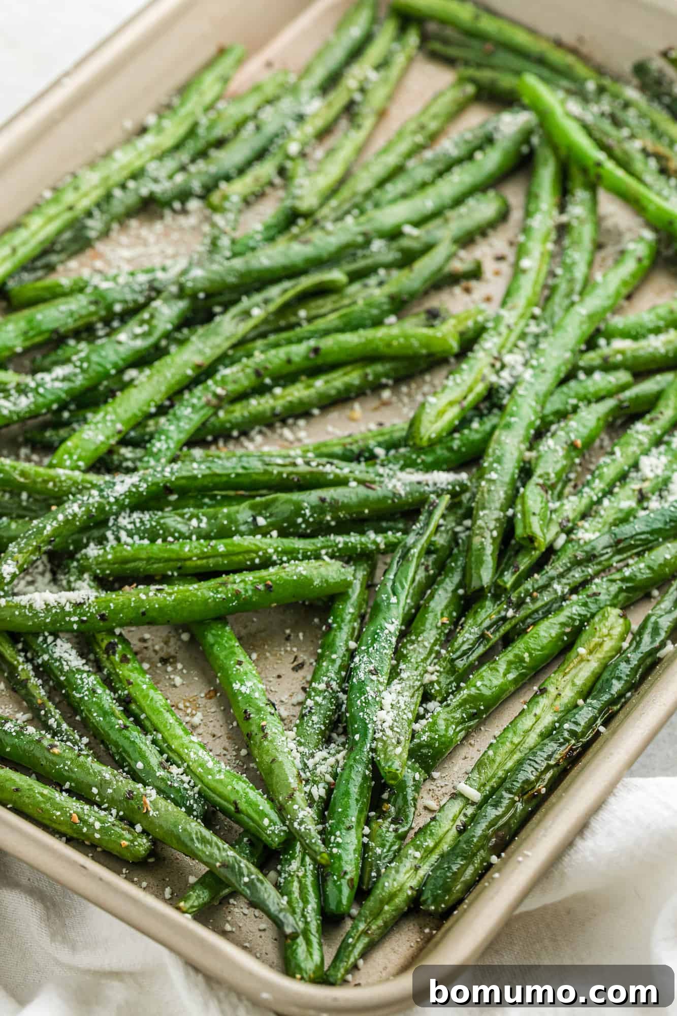 Roasted green beans with parmesan on a sheet pan.