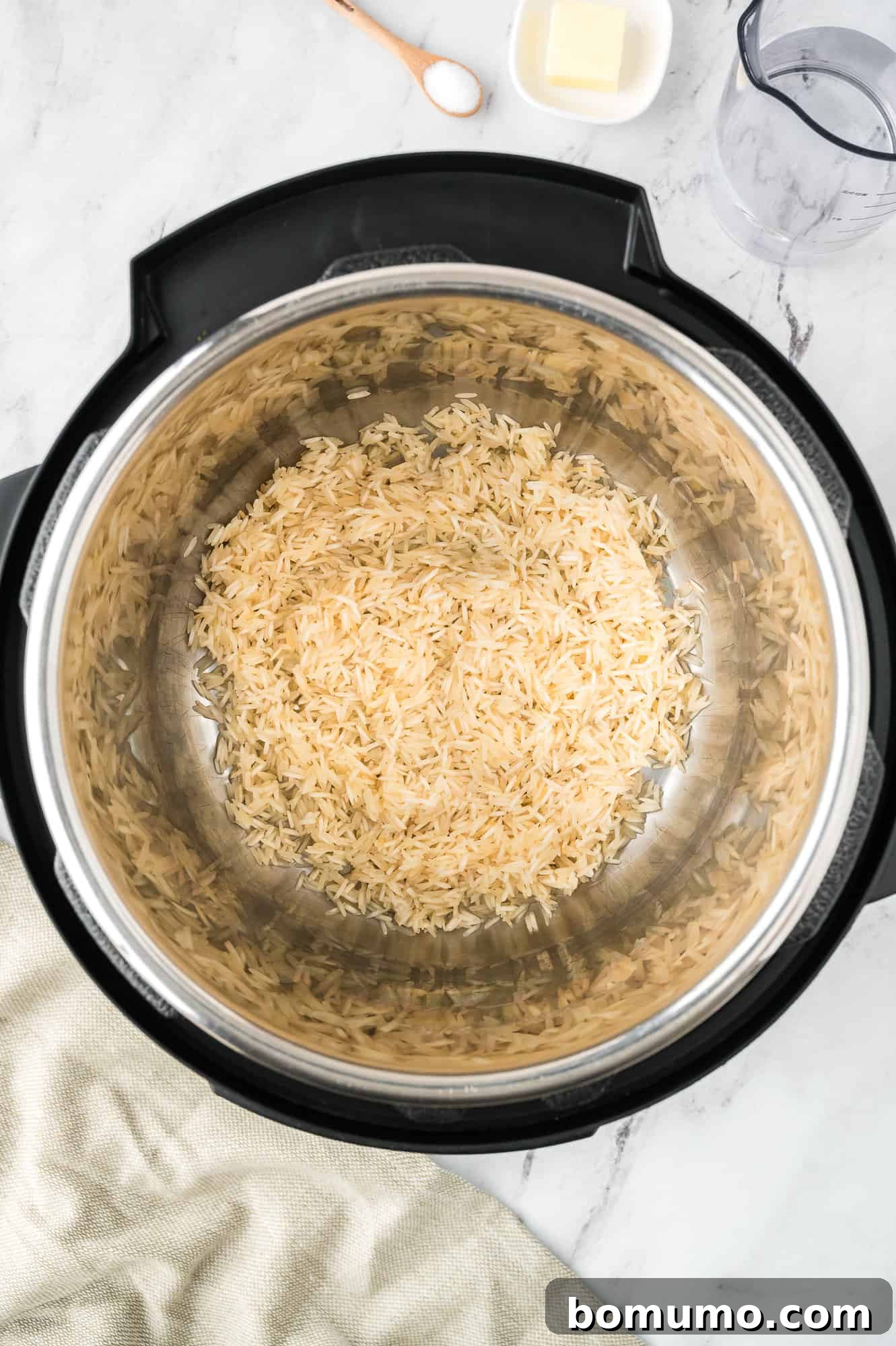 Rinsed basmati rice placed into the Instant Pot's inner pot, ready for other ingredients.