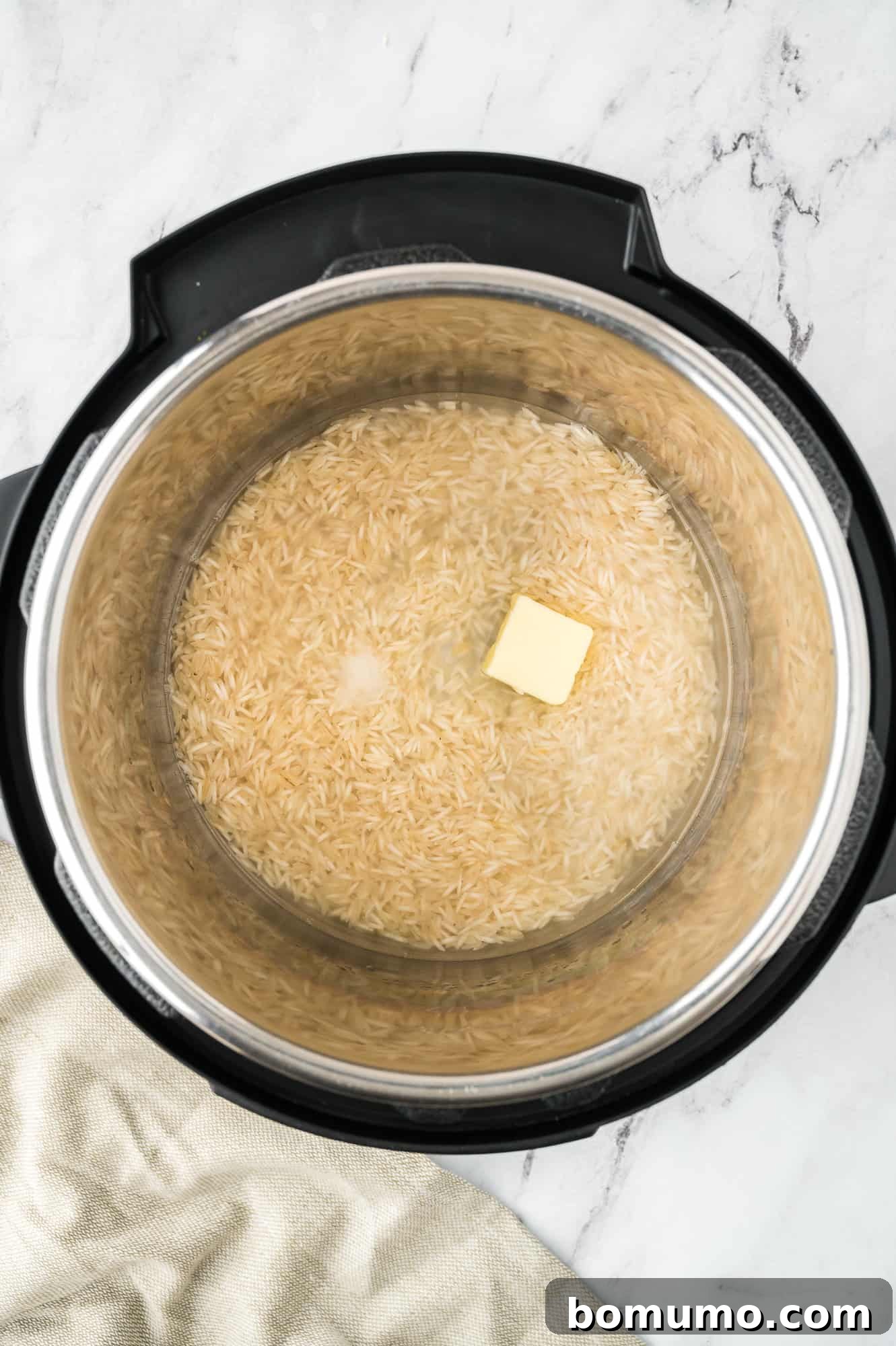 All ingredients – rinsed rice, water, oil, and salt – combined in the Instant Pot, before cooking.