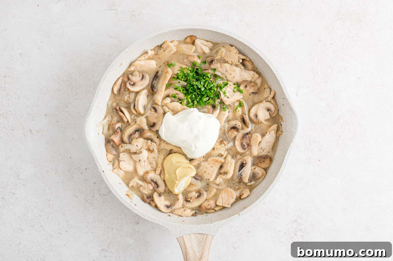 Velvety Chicken Stroganoff 11 Sour cream, Dijon mustard, and parsley added to the stroganoff, not yet stirred in.