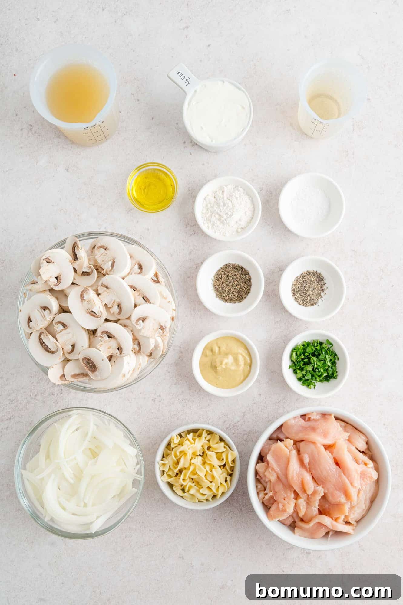 Velvety Chicken Stroganoff 4 All the fresh ingredients laid out for making chicken stroganoff, including chicken, mushrooms, and herbs.