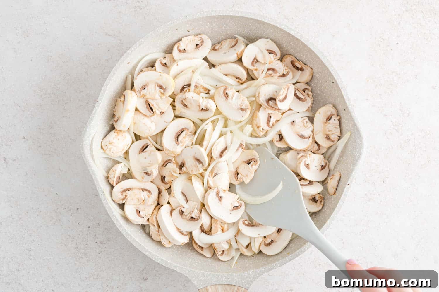 Velvety Chicken Stroganoff 6 Raw mushrooms and onions ready for cooking in a skillet.