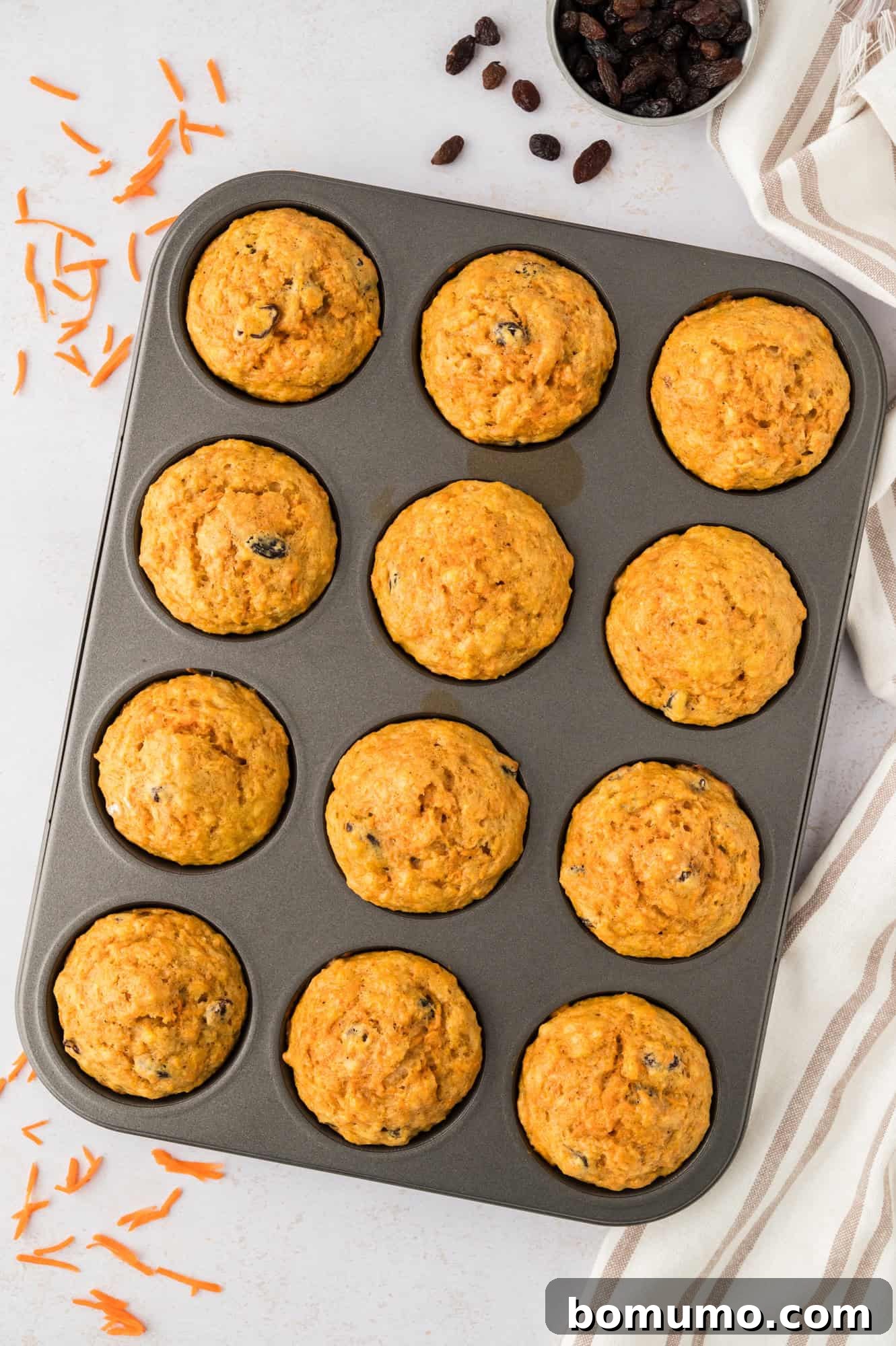 Muffins in a tin, after baking, golden brown and perfectly risen.
