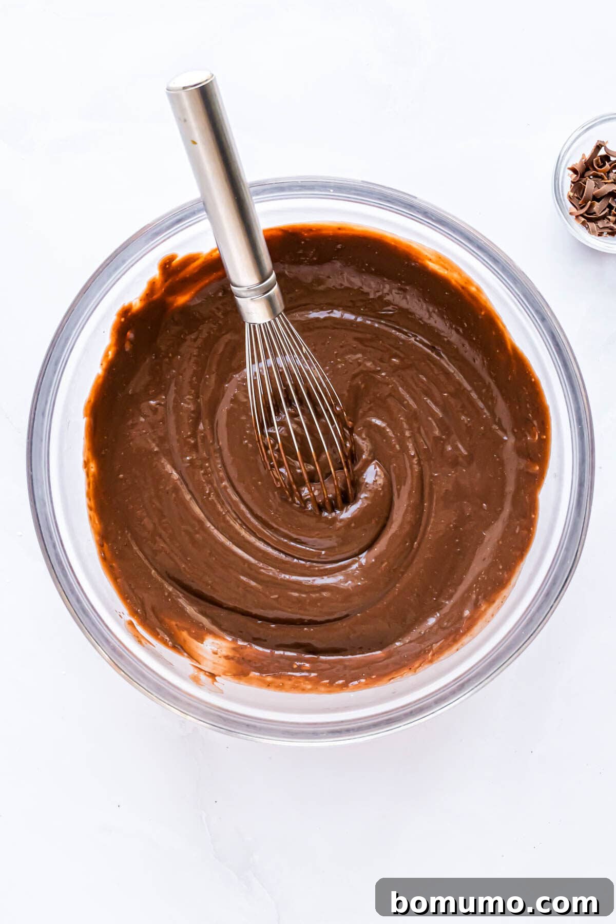 The chocolate pudding mixture, now thickened and smooth, ready to be spread, in a clear glass bowl.