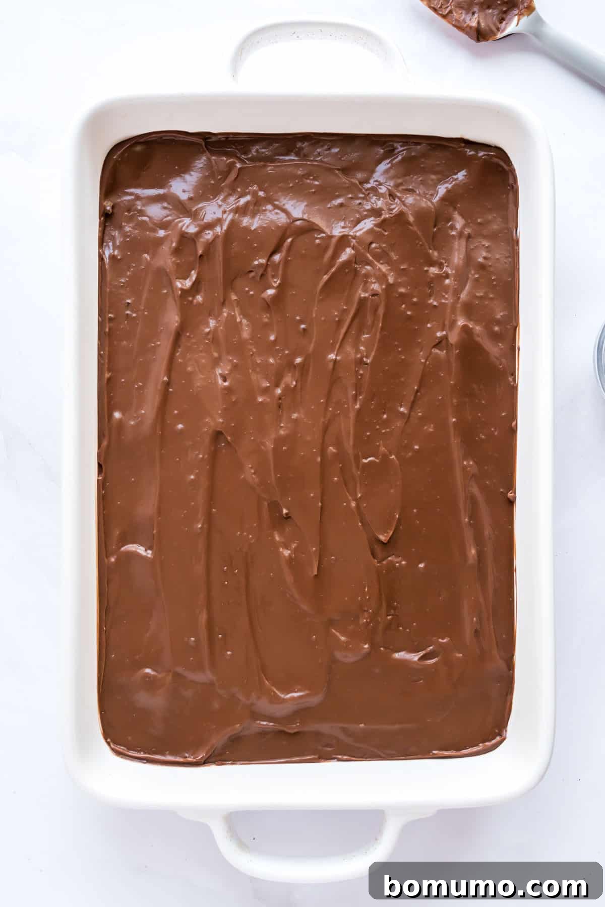The rich chocolate pudding layer carefully spread over the cream cheese layer in the baking dish.