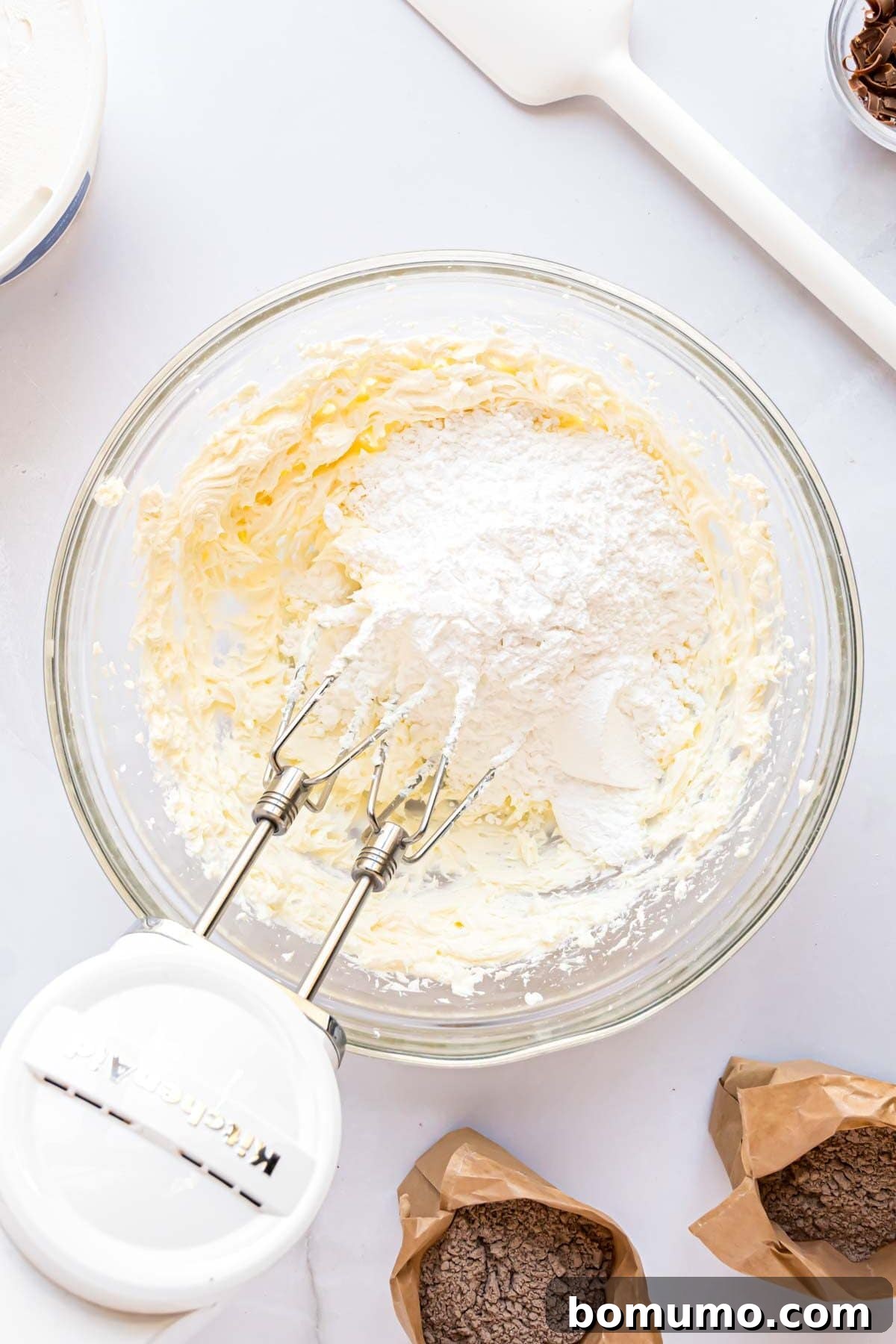 Ingredients for the cream cheese layer being mixed together in a bowl, showcasing the creamy texture.