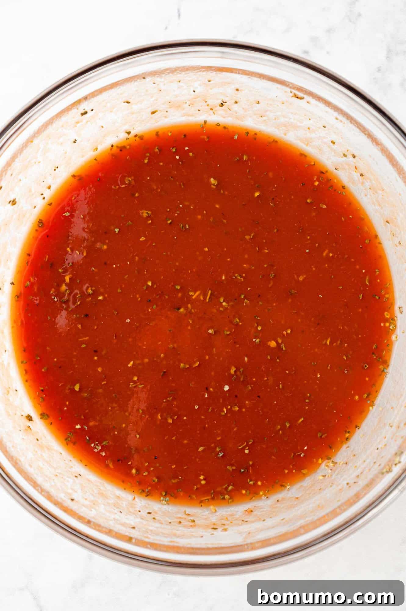 Rice-Studded Meatballs 8 Tomato sauce mixed up in clear glass bowl.