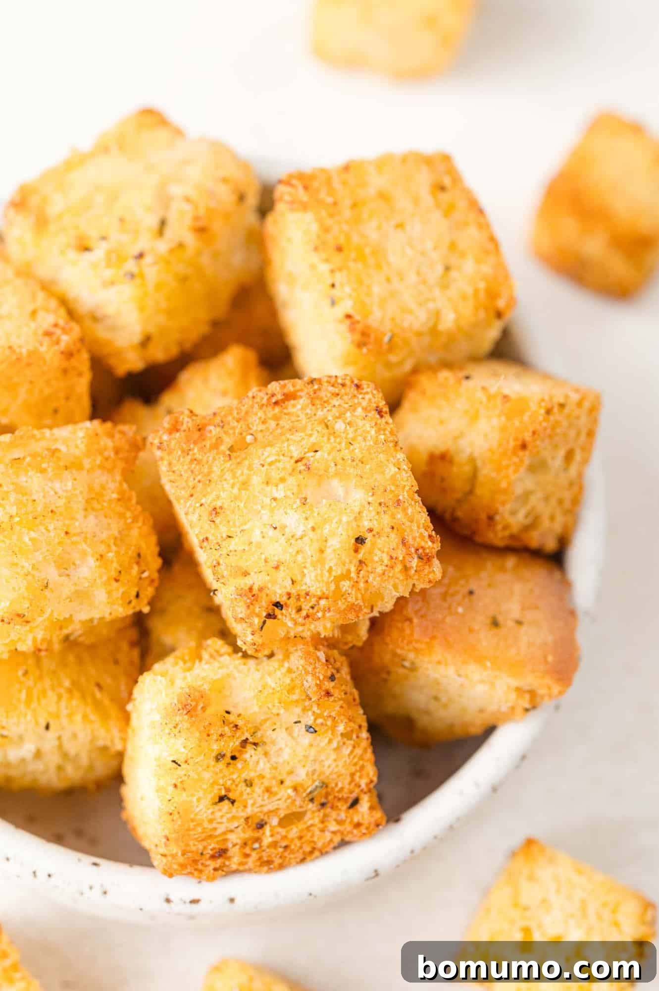 Crispy homemade air fryer croutons in a small white bowl, ready to be served.