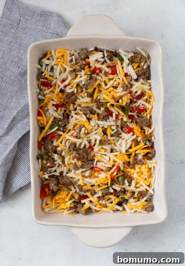 Hash brown breakfast casserole ingredients in baking dish, mixed together.