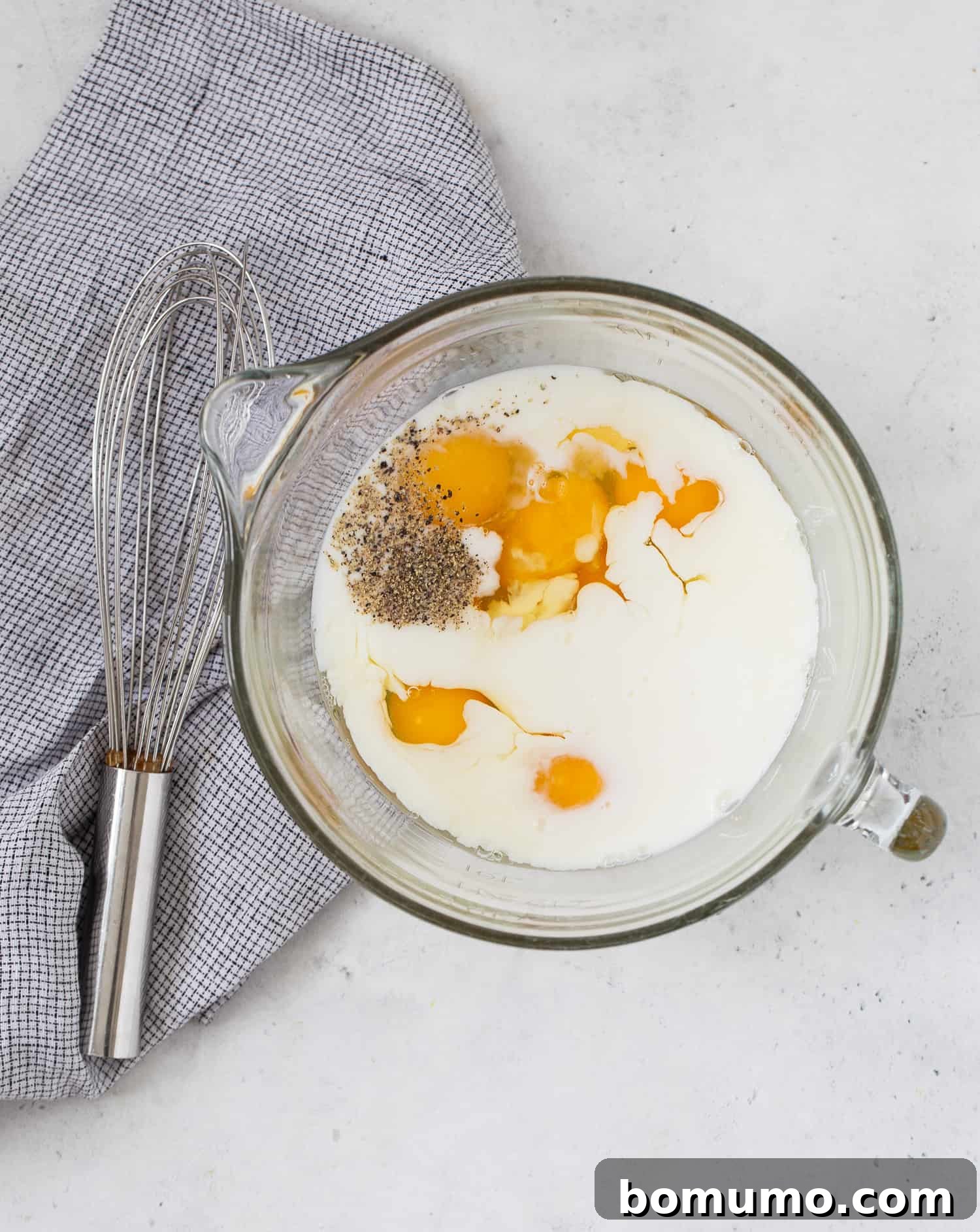Eggs, milk, and seasonings, not yet mixed together.