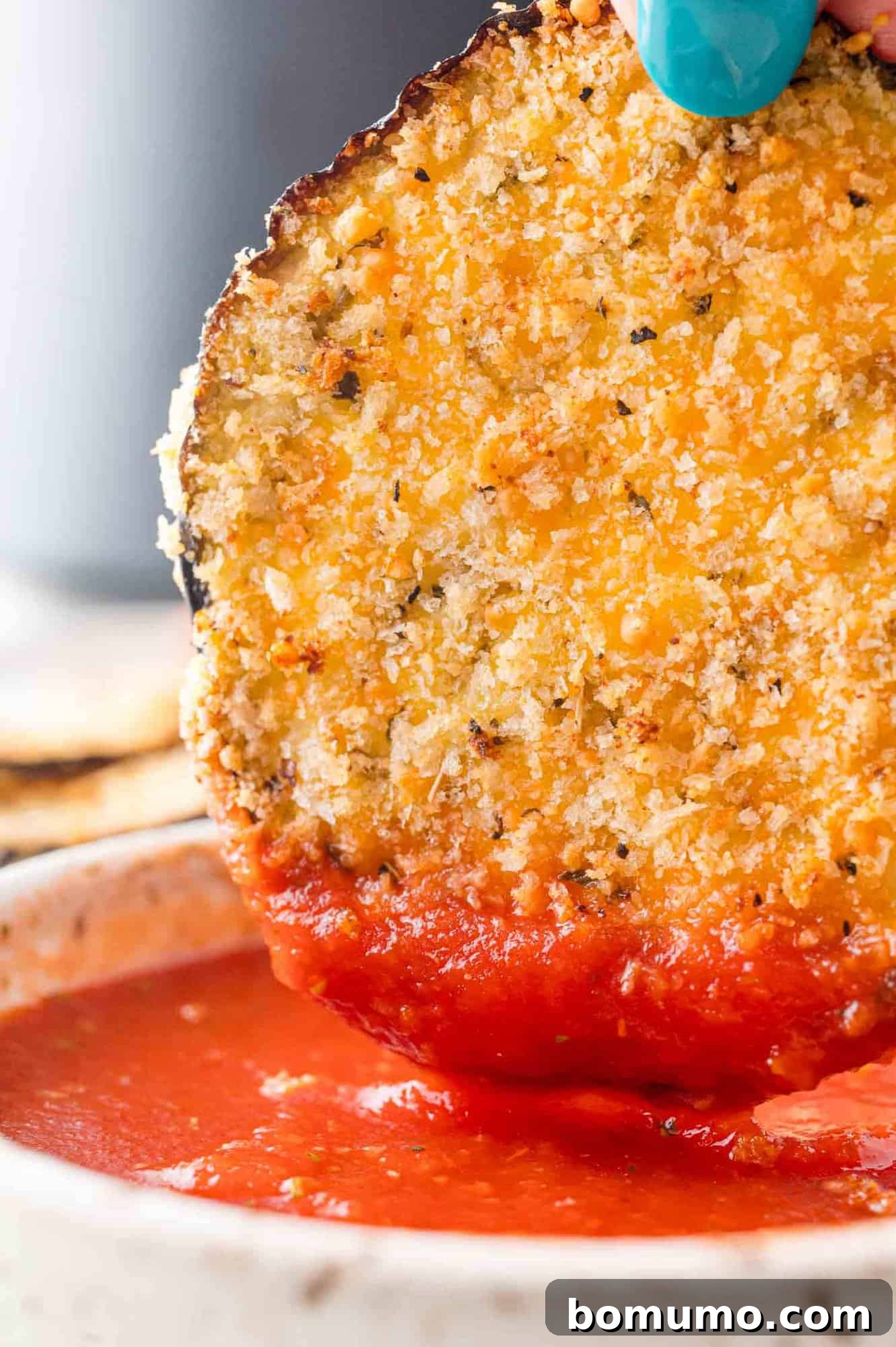 Crispy Air Fried Eggplant 3 Slice of air fryer eggplant being dipped in marinara sauce.