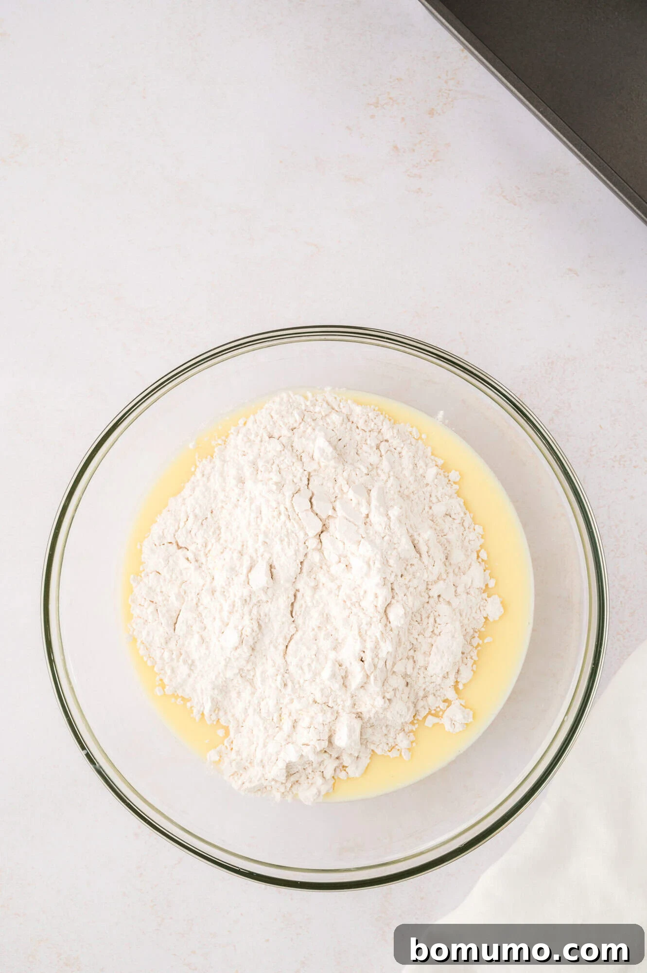 Dry ingredients added to wet ingredients in a large mixing bowl.