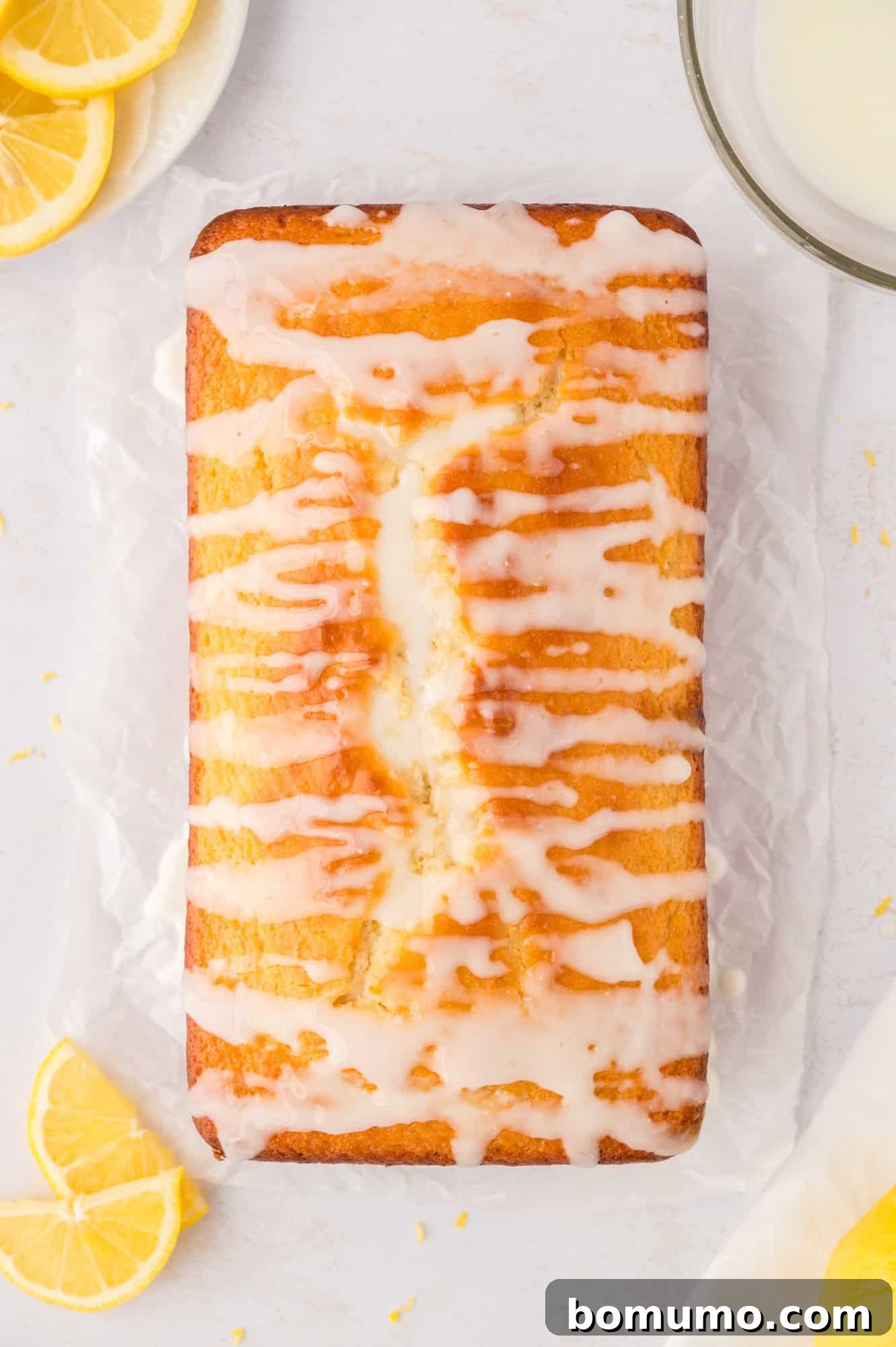 Glaze drizzled over lemon loaf.