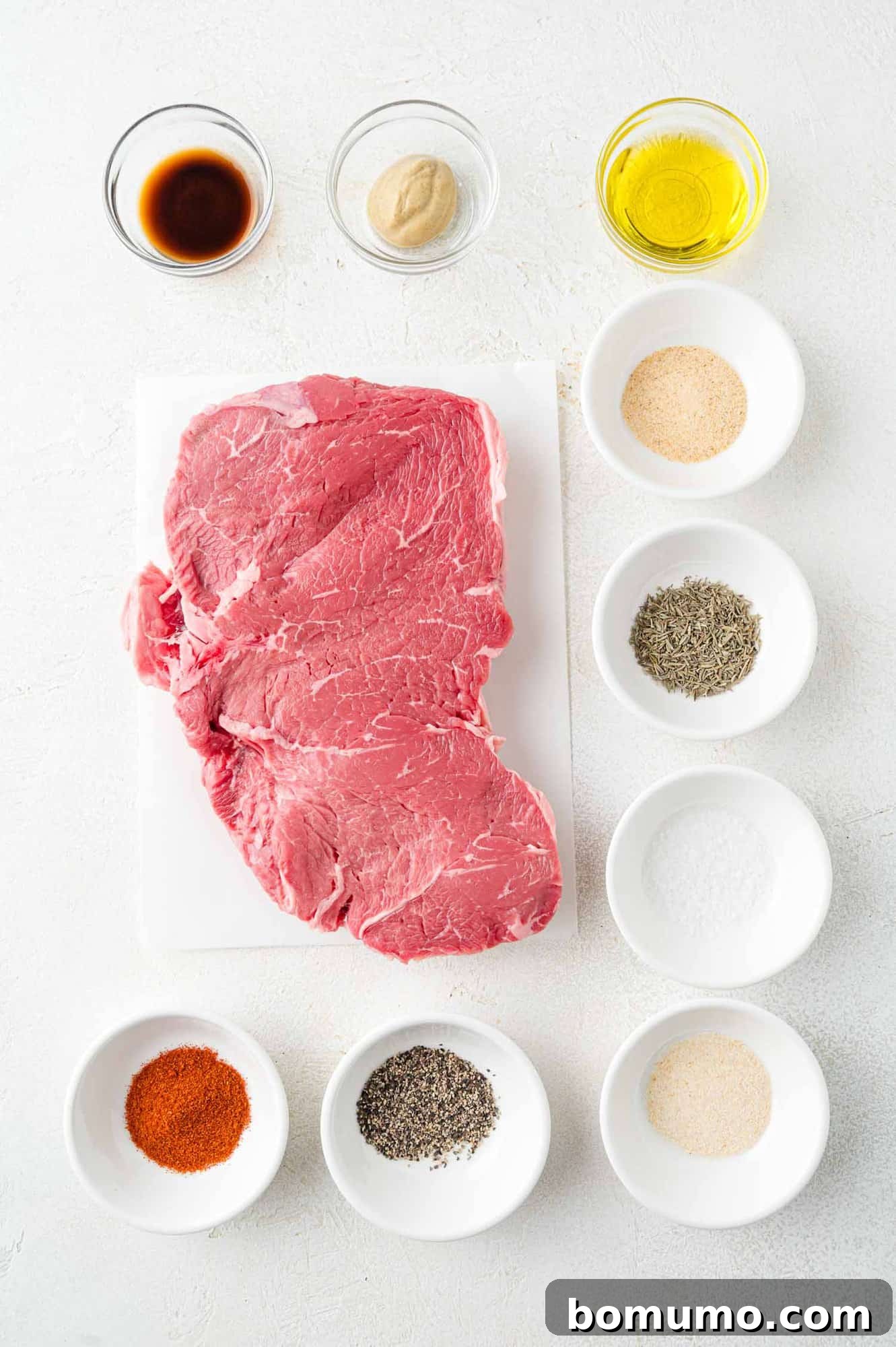 A vibrant display of all the fresh ingredients needed for the steak bites, including various spices, olive oil, and sauces, neatly arranged for preparation.