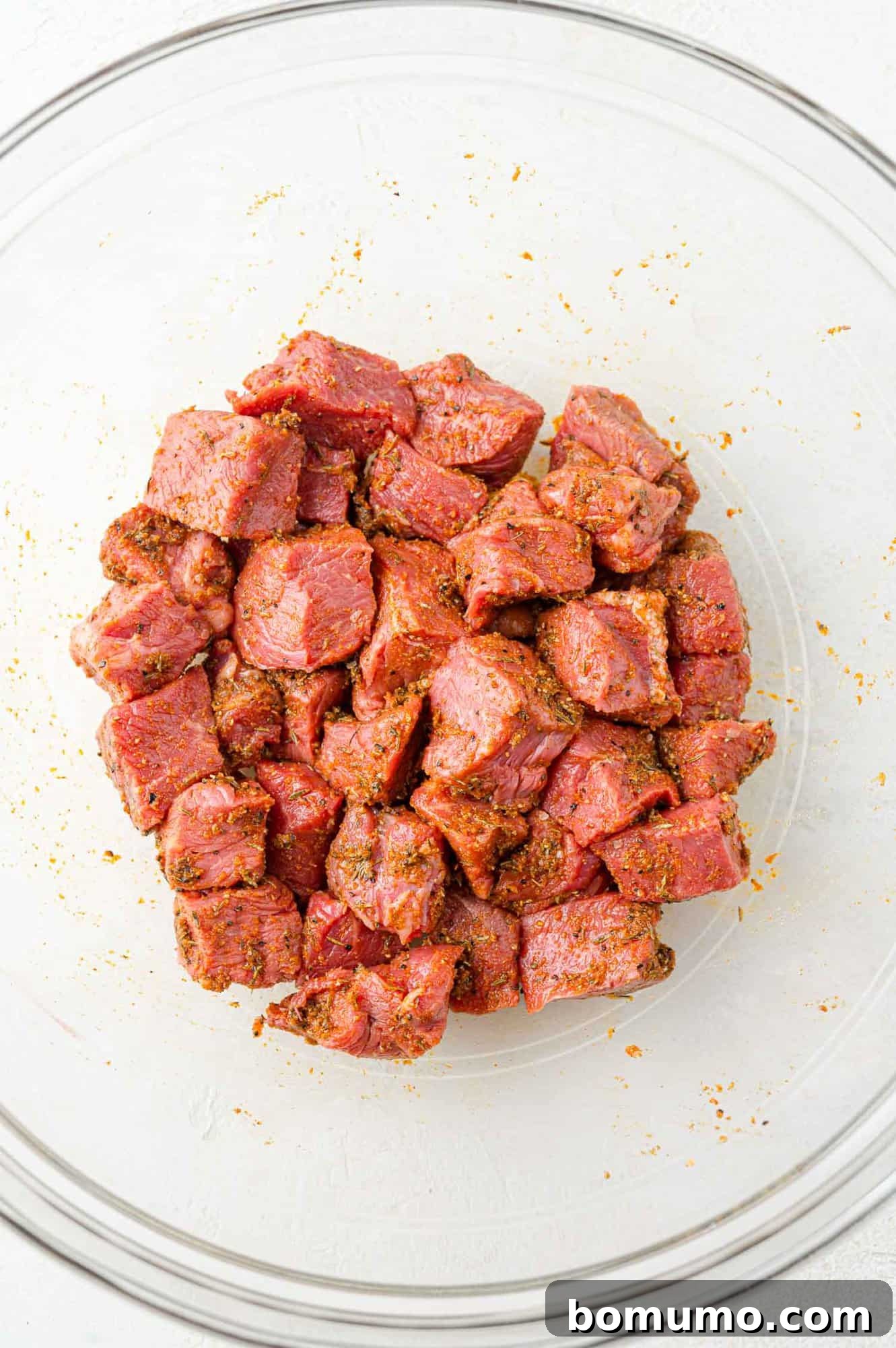Bite-sized steak pieces fully coated in the savory marinade, ready to absorb flavors before air frying.