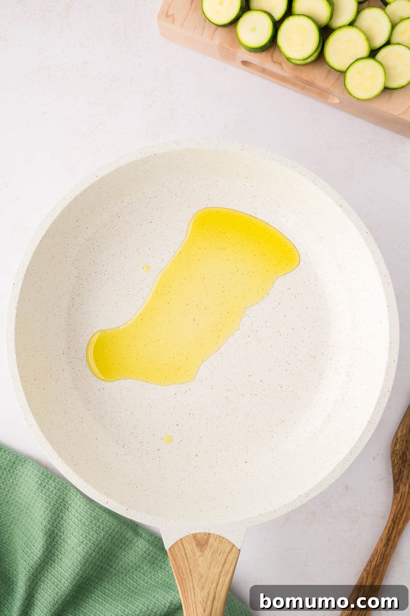 Olive oil heating in a frying pan, ready for the zucchini.