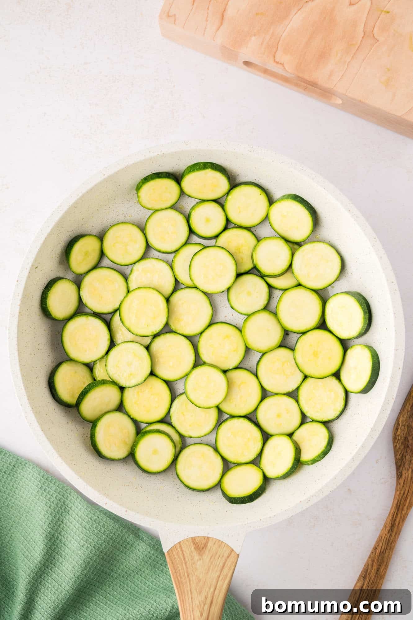 Zucchini slices arranged in a single layer in the skillet for even cooking and browning.