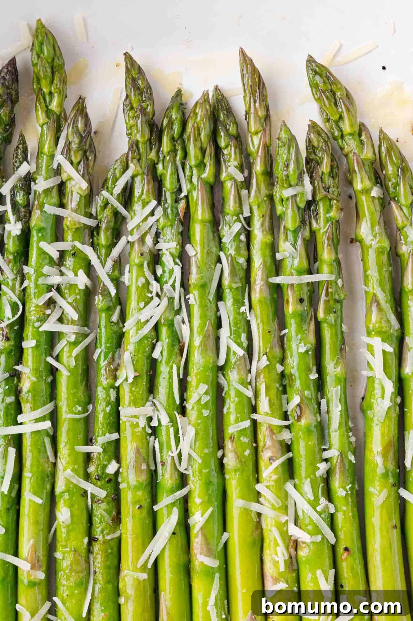 Sautéed asparagus spears topped with Parmesan cheese, ready to be served as a healthy side dish.