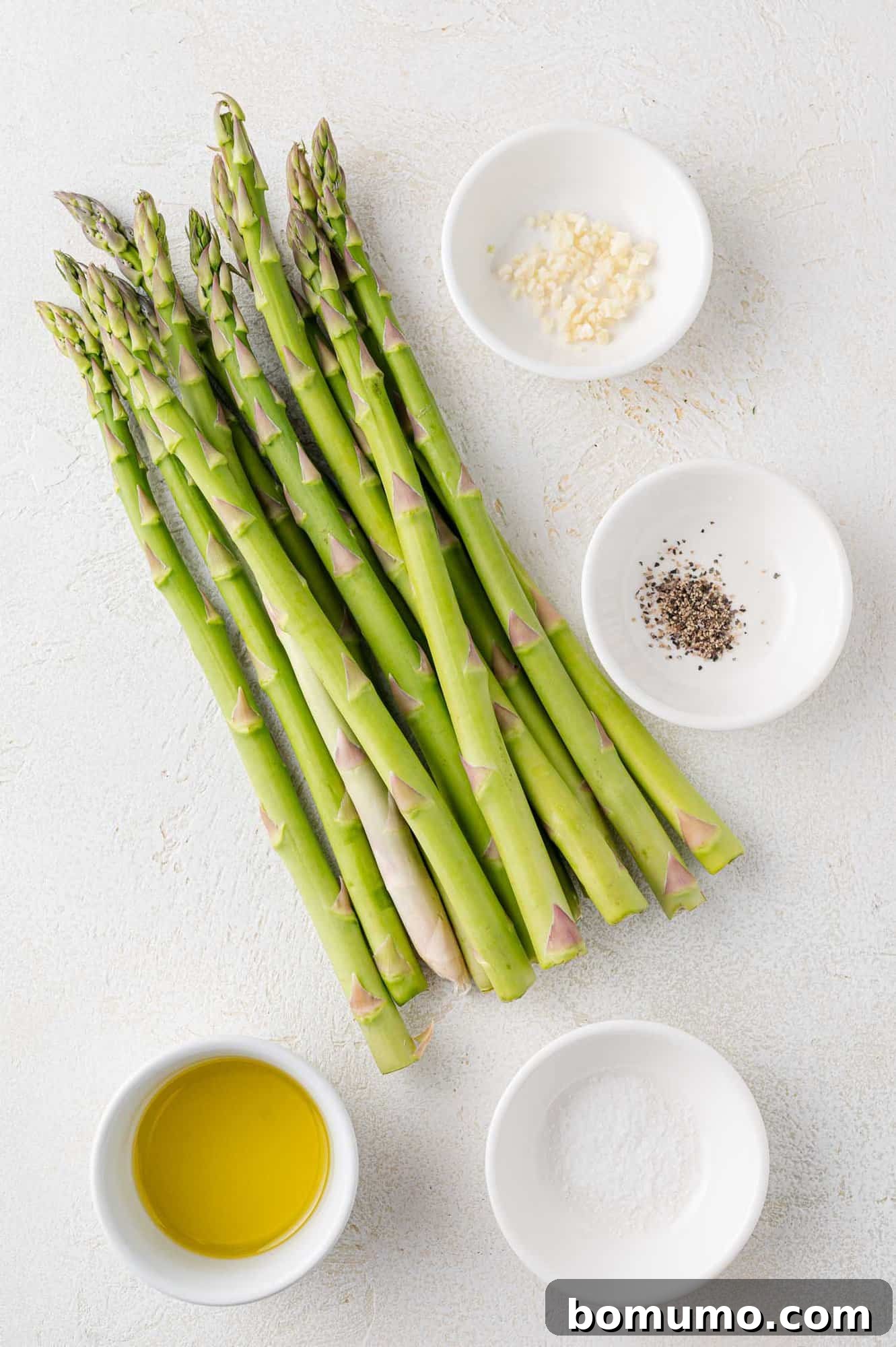 Fresh asparagus and other ingredients laid out for cooking.
