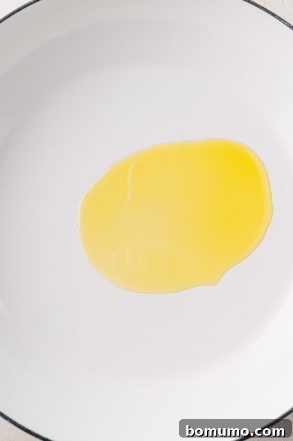 Olive oil heating in a large skillet, ready for asparagus.