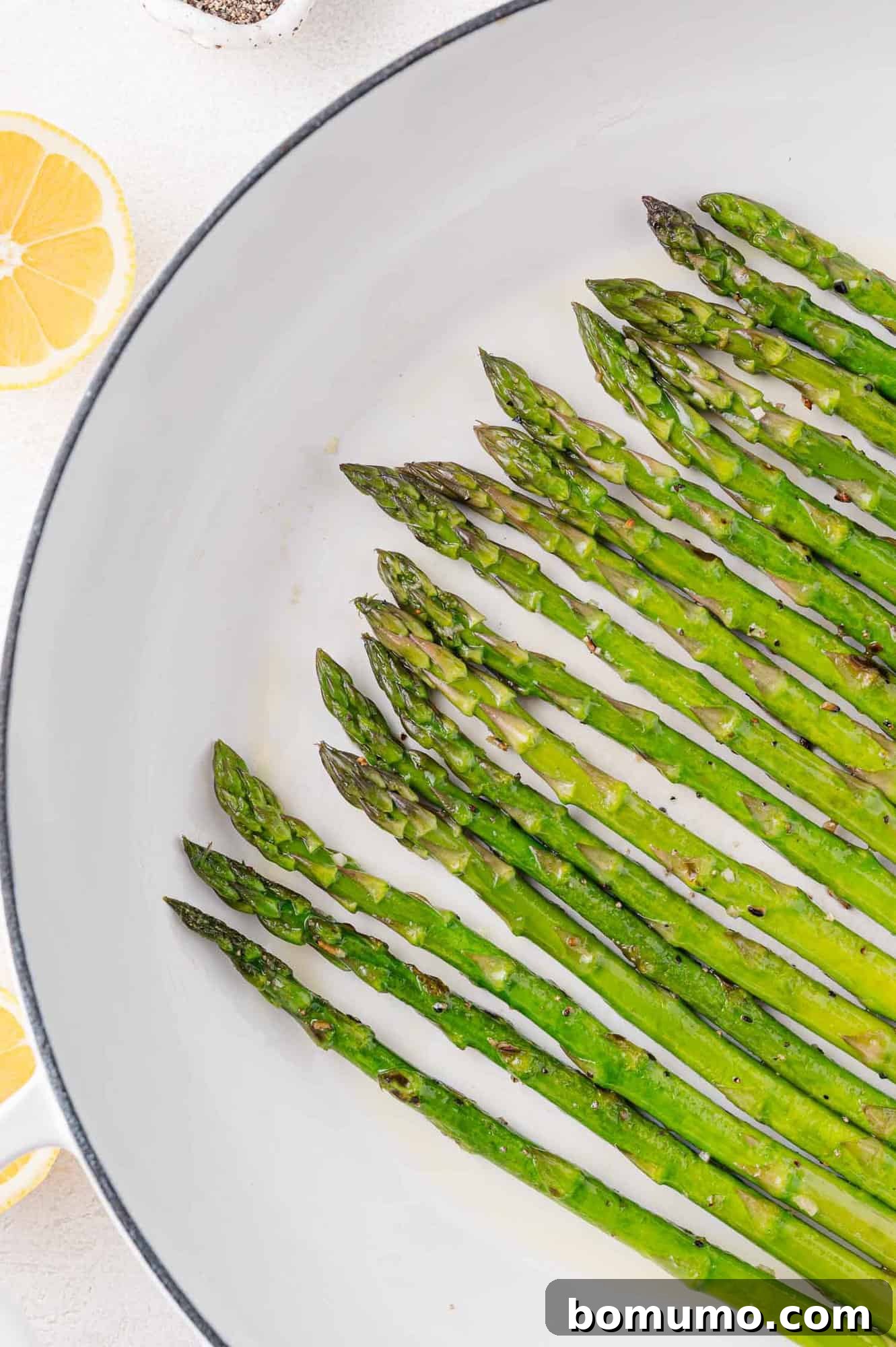 Perfectly cooked asparagus retaining its vibrant green color in a frying pan.