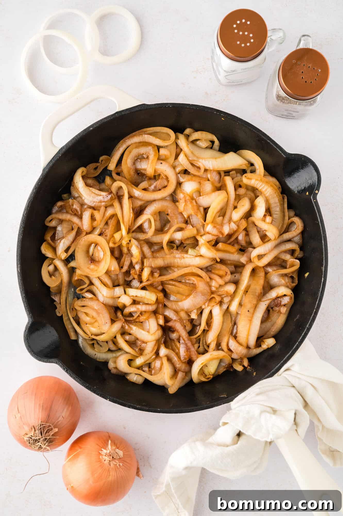 A pan filled with beautifully finished sautéed onions, glazed and tender, ready to be served as a flavorful addition to any meal.