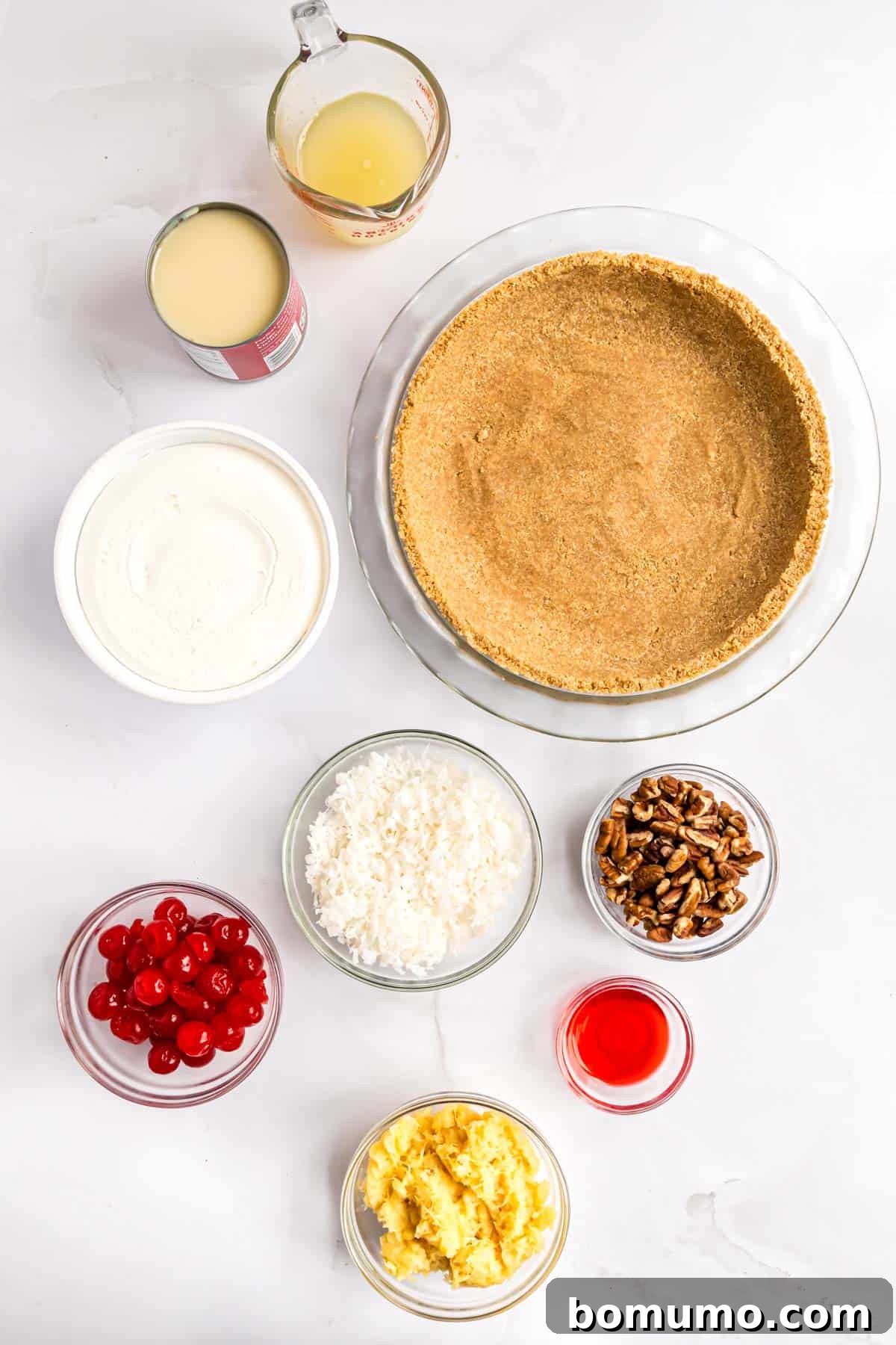 Golden Treasure Pie 4 An overhead view showcasing the individual ingredients required for a Millionaire Pie, neatly arranged before mixing. This includes maraschino cherries, crushed pineapple, coconut flakes, pecans, sweetened condensed milk, and lemon juice.