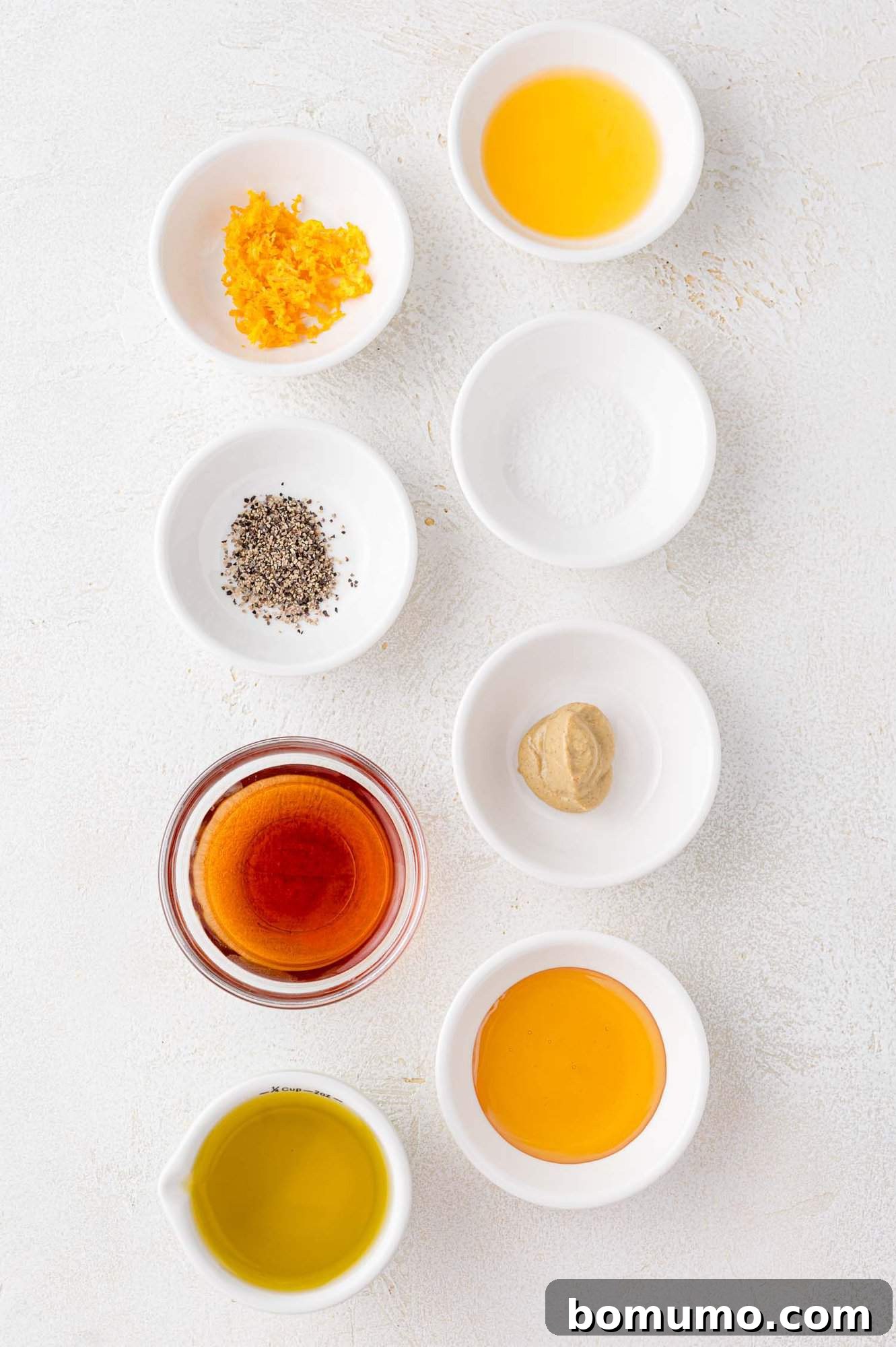 Individual bowls showcasing each ingredient required for the bright and zesty mandarin orange salad dressing.
