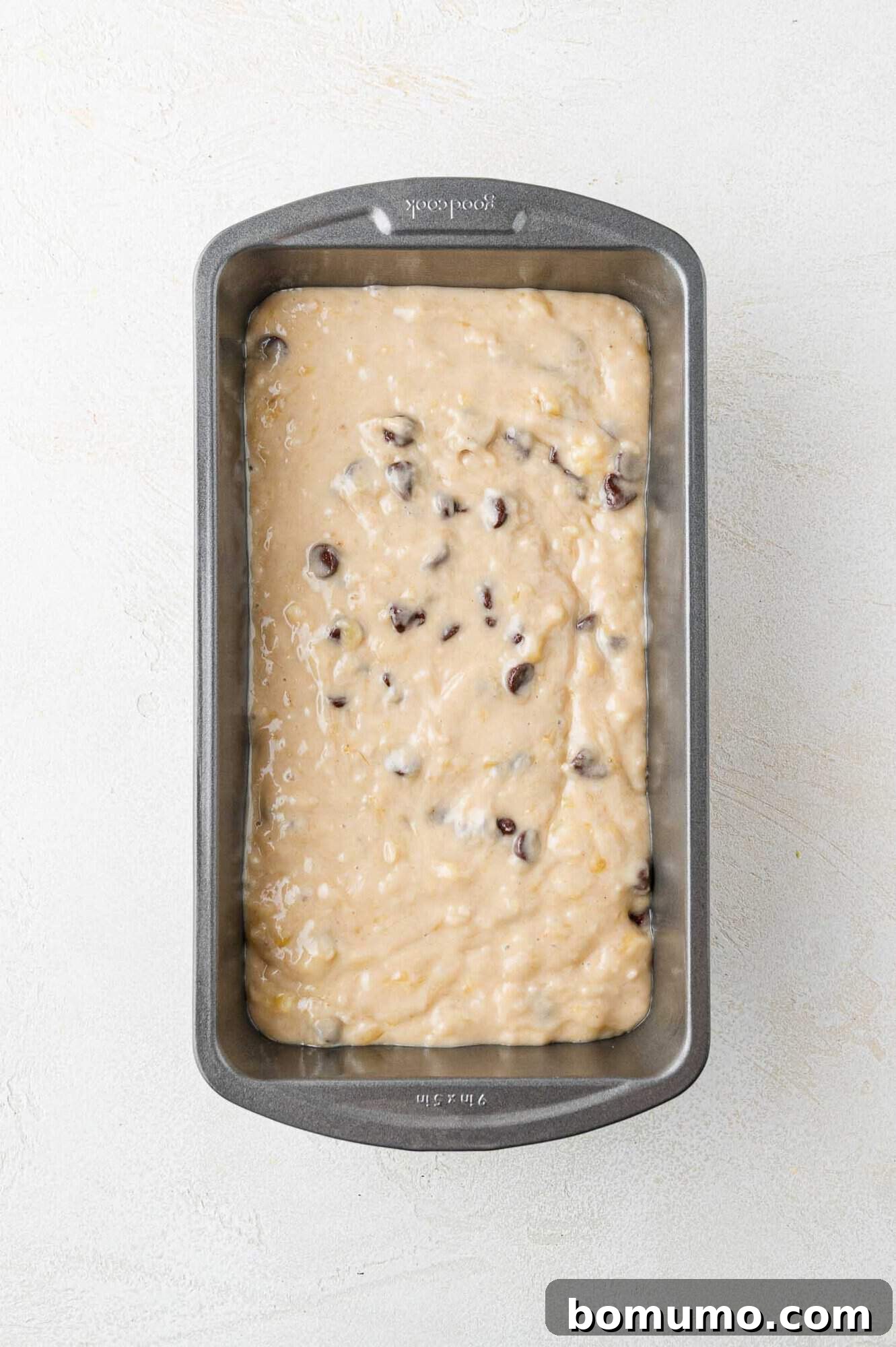 Smoothly spread banana bread batter in the prepared loaf pan, ready for its topping.