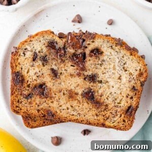 Two enticing slices of chocolate chip banana bread on a small white plate, ready to be enjoyed.