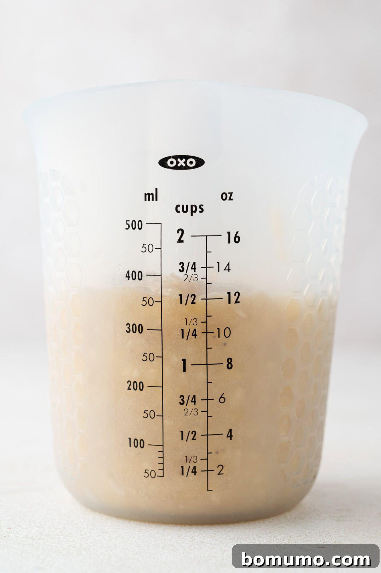 Precisely 1.5 cups of mashed bananas in a clear glass measuring cup, ready for the next step.