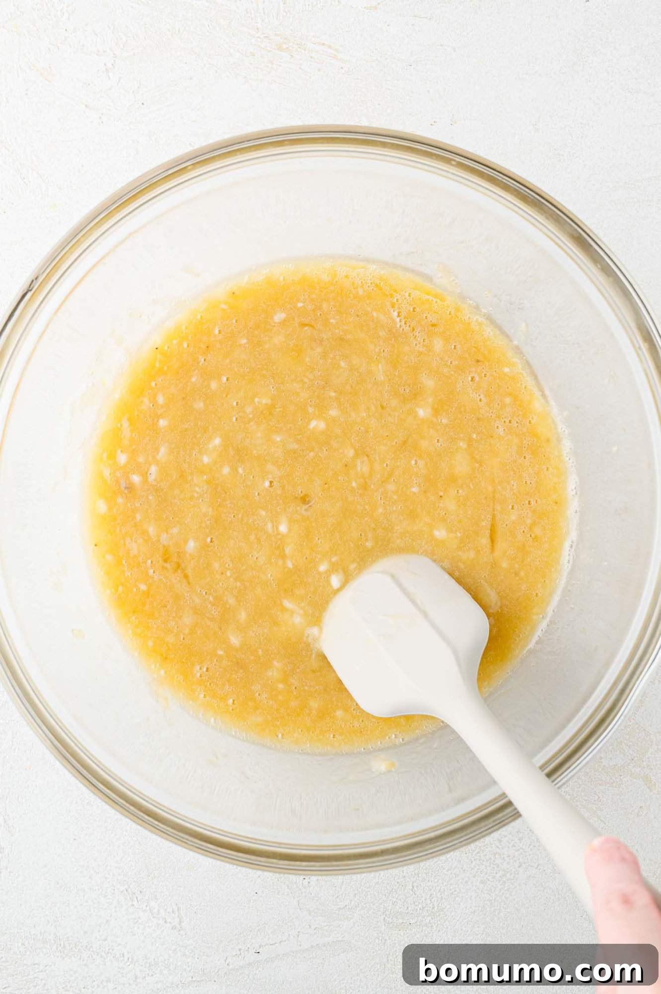 The wet ingredients beautifully mixed in a clear glass bowl, forming a smooth and uniform base.
