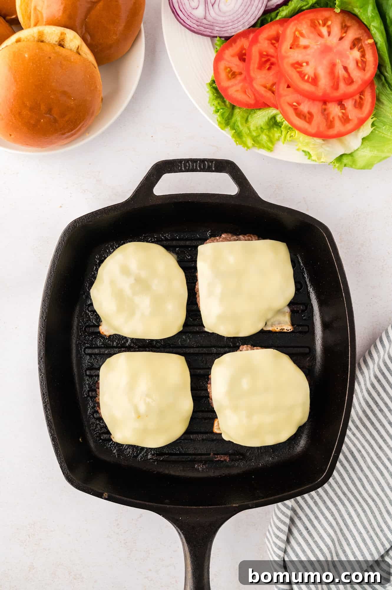 The Cali Dream Burger 12 Slices of Monterey Jack cheese melting beautifully on top of the hot, cooked burger patties.