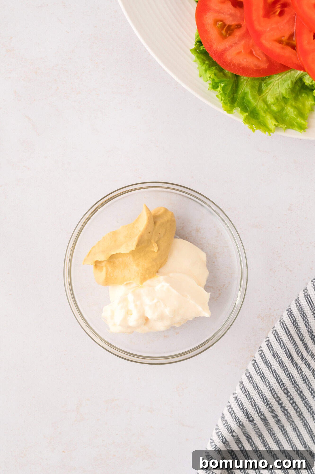 The Cali Dream Burger 13 Separate dollops of mayonnaise and Dijon mustard in a small bowl, before mixing them into a sauce.