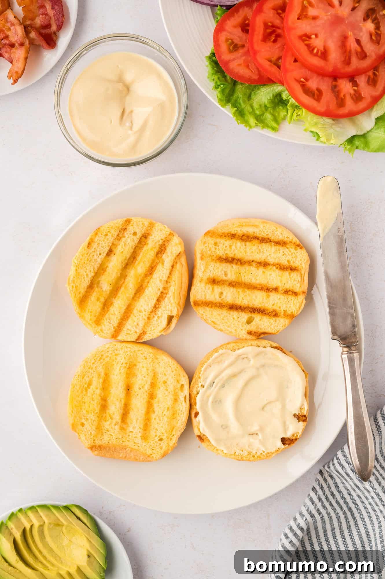 The Cali Dream Burger 15 Toasted burger buns, with one showing the creamy sauce spread on its bottom half.