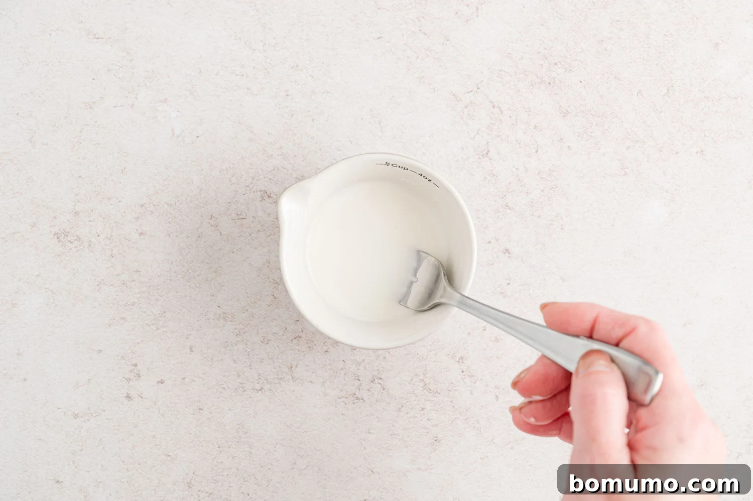 A small bowl containing a smooth cornstarch slurry, prepared to thicken the slow cooker beef stew.