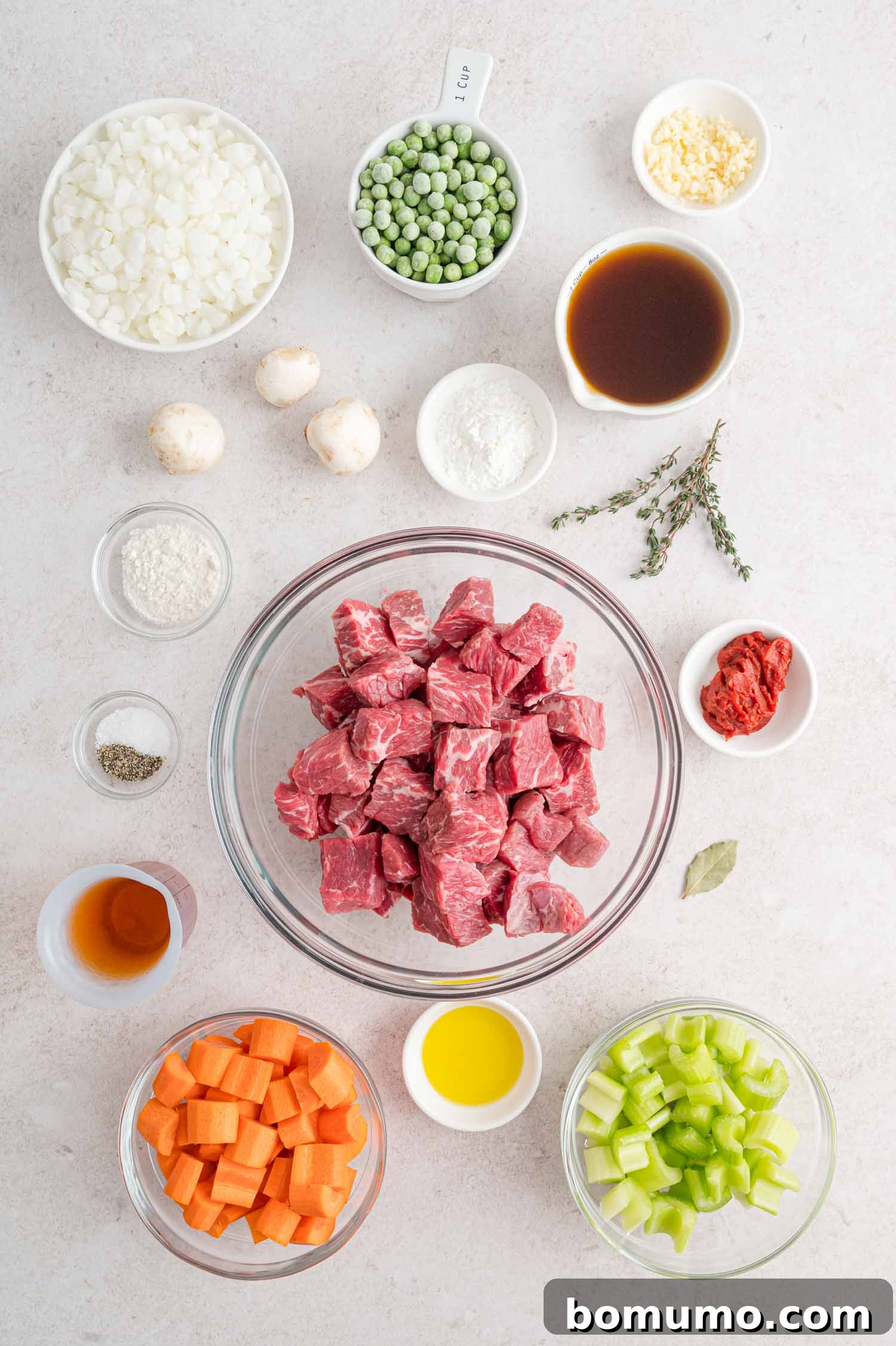 All the fresh ingredients for Slow Cooker Beef Marsala Stew neatly arranged in separate bowls, ready for preparation.