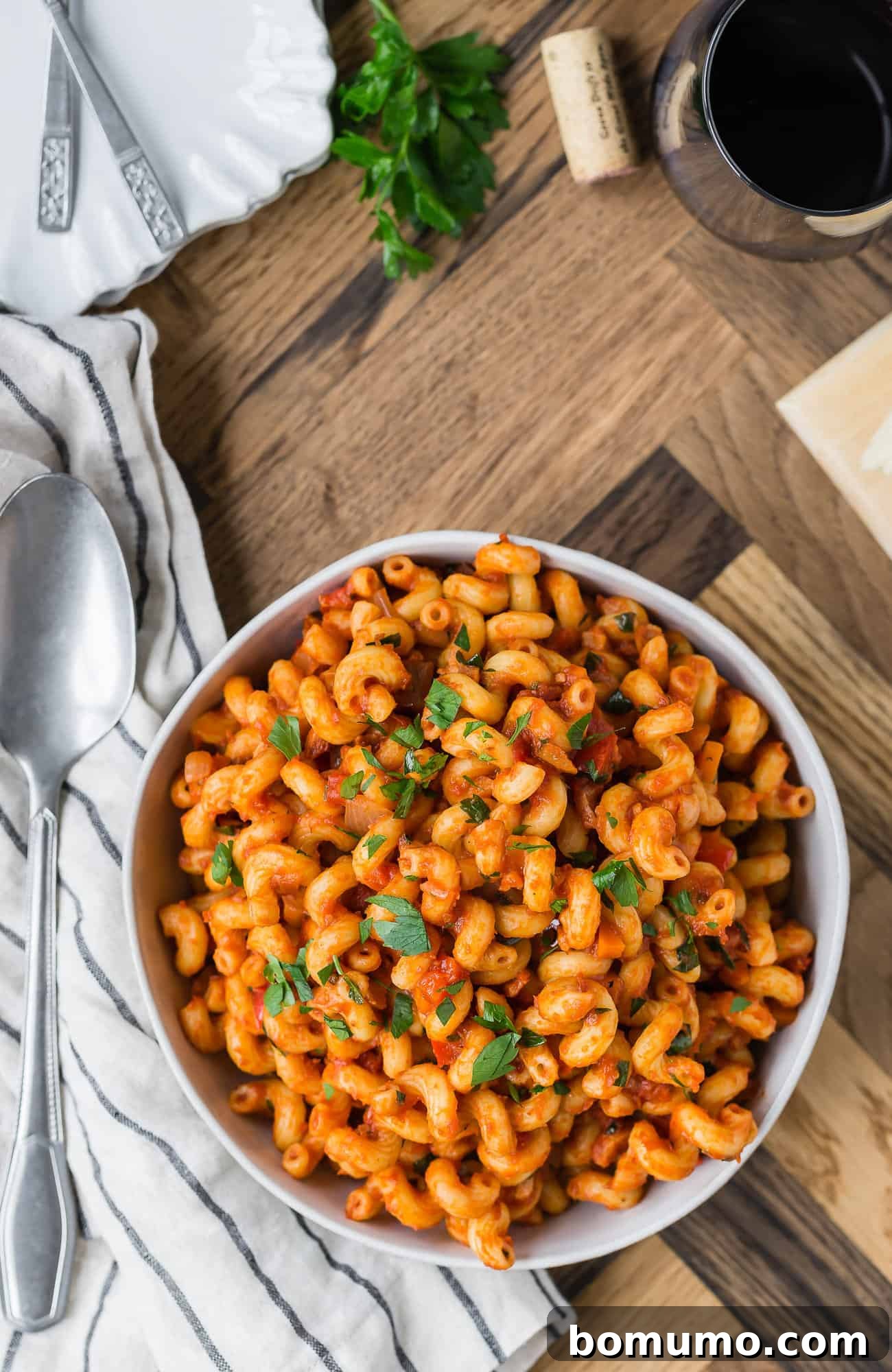 Overhead view of a generous serving of pasta with pancetta and smoky tomato sauce in a white serving bowl, ready to be enjoyed.