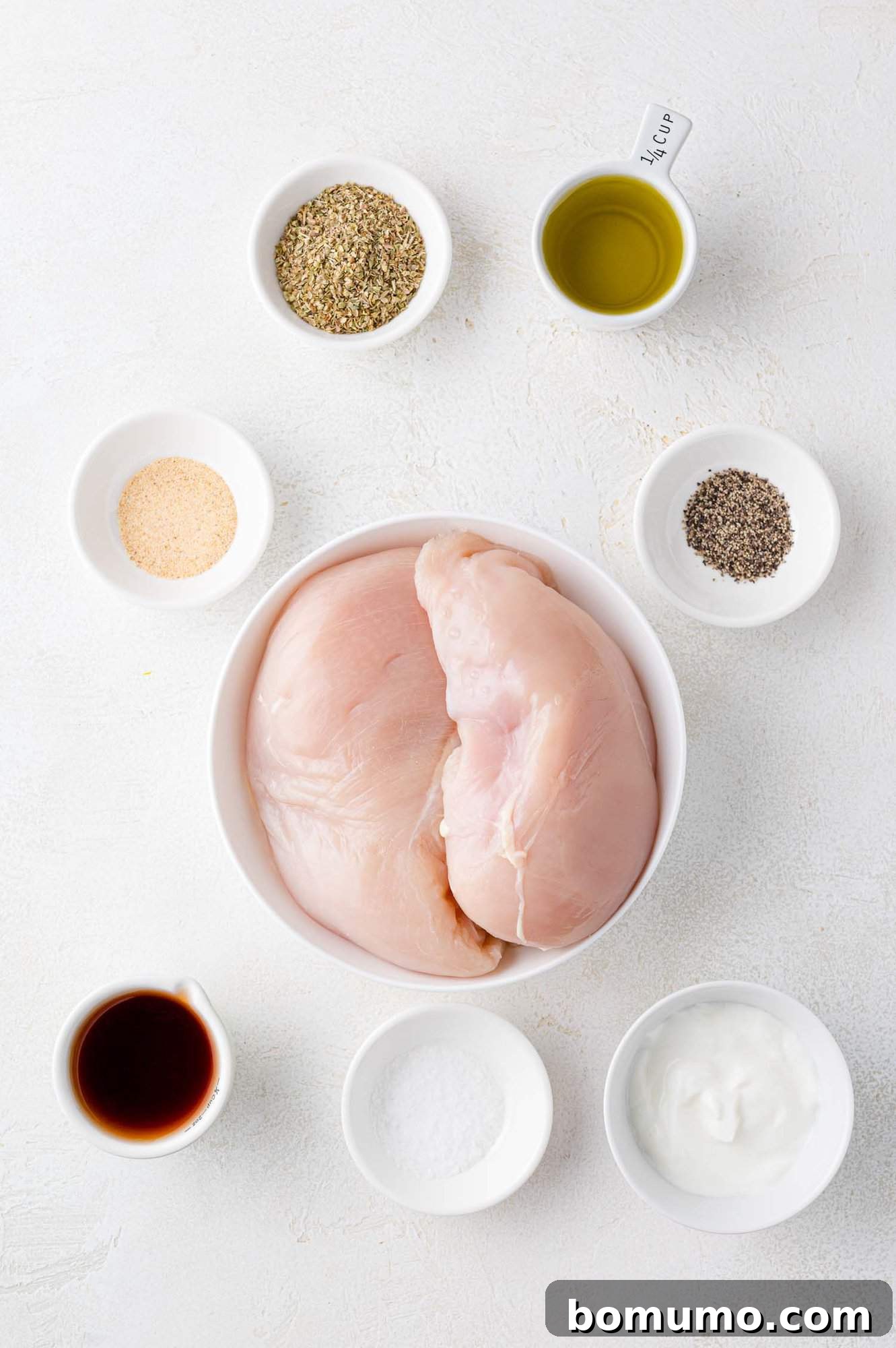 Ingredients needed for recipe, including chicken breasts on a cutting board.