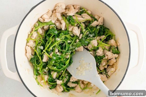 The baby kale, now significantly reduced in volume and softened after being cooked down in the soup pot.