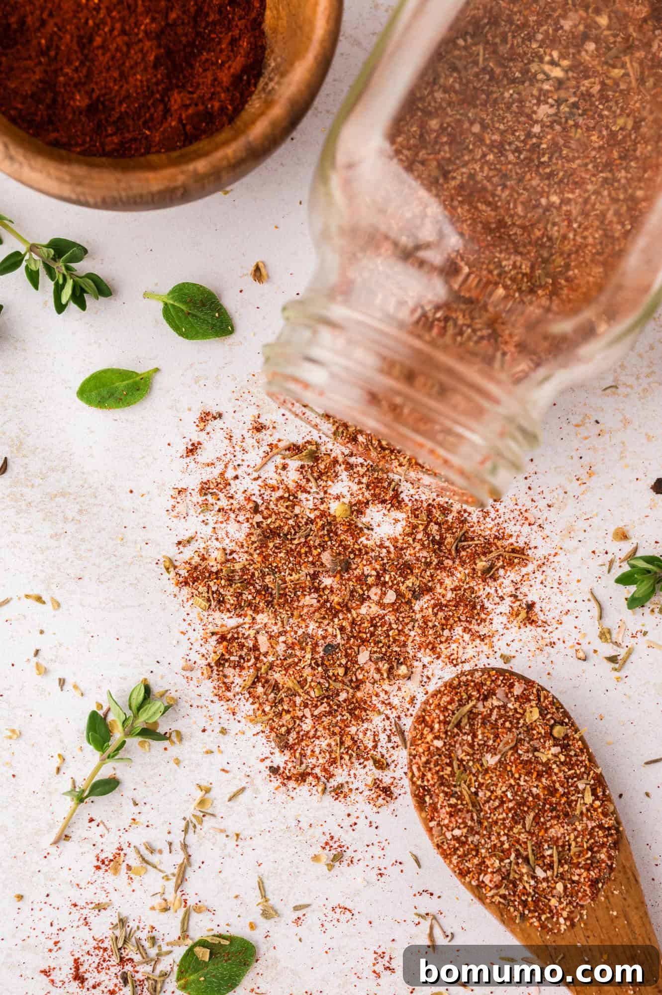 Homemade blackening seasoning stored elegantly in a jar, with a portion delicately scooped onto a spoon, ready to infuse flavor.