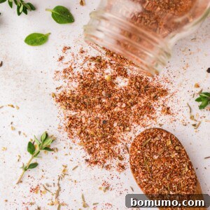 Blackening seasoning spilling out of a jar, and on a spoon.