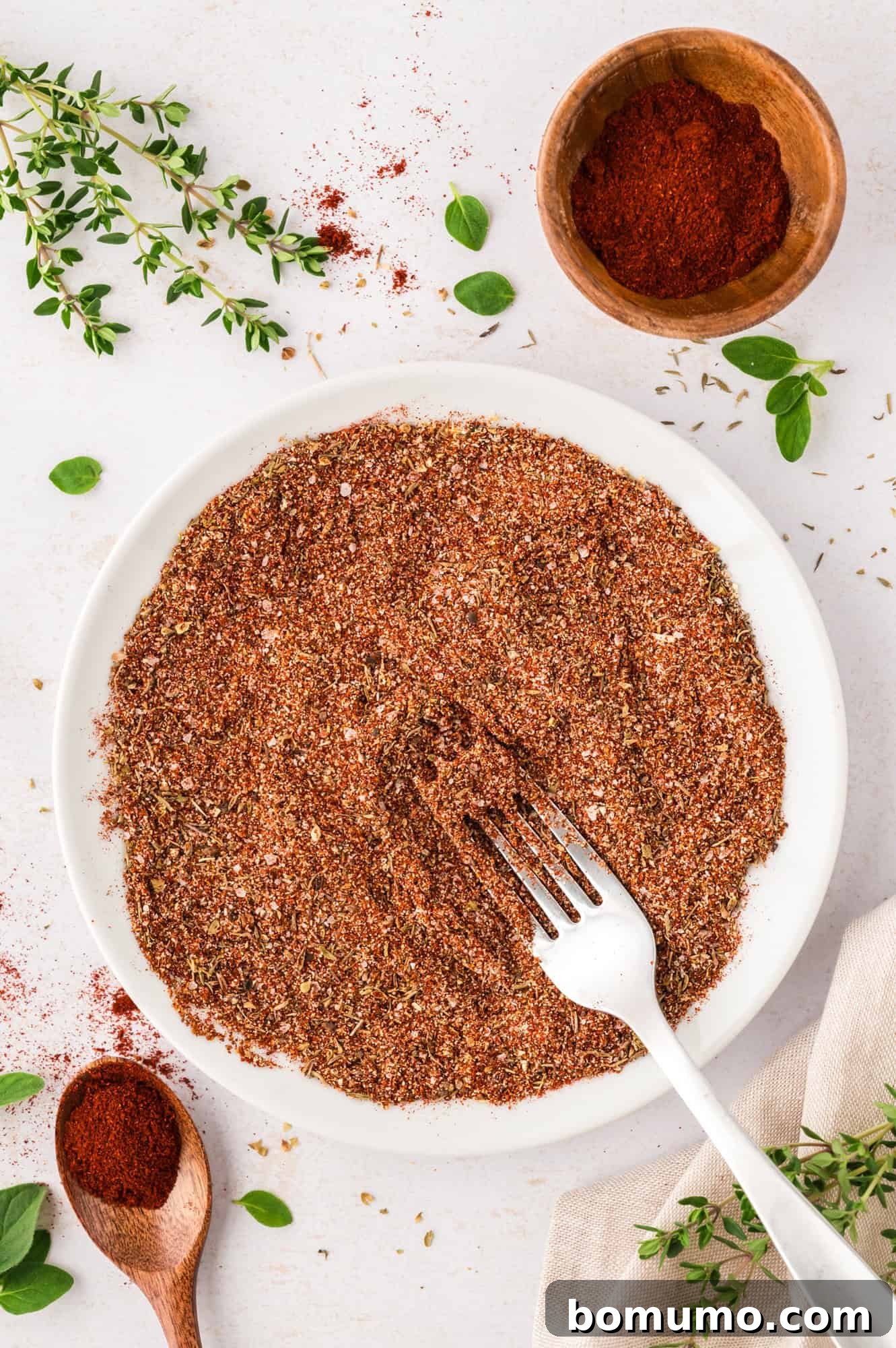 The blackening seasoning fully mixed in a bowl, with a fork resting inside, showcasing its rich and even blend of spices.