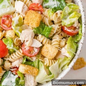Chicken caesar pasta salad in a large serving bowl, ready to be enjoyed.
